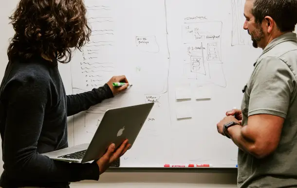 photo of two people using whiteboard