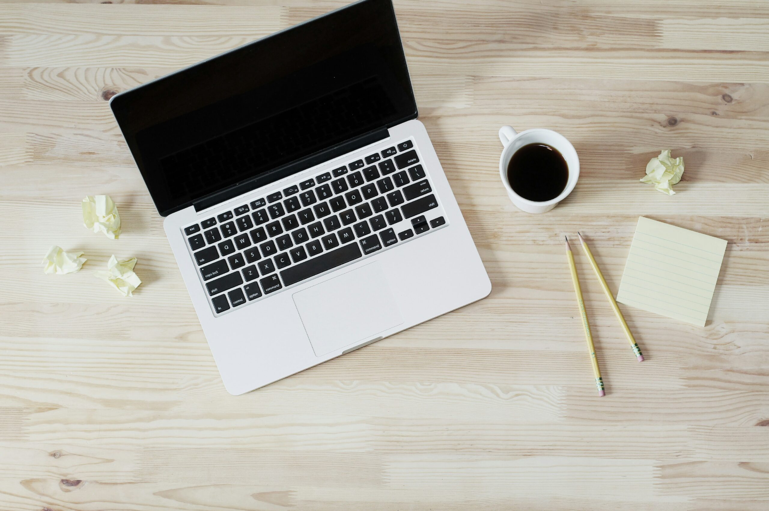 Photo of computer, coffee mug, and pencils with sticky notes